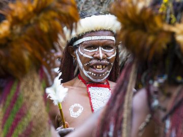 A matriarch from the Dani tribe, dressed in traditional gear, leads a dance in Papua, Indonesia.