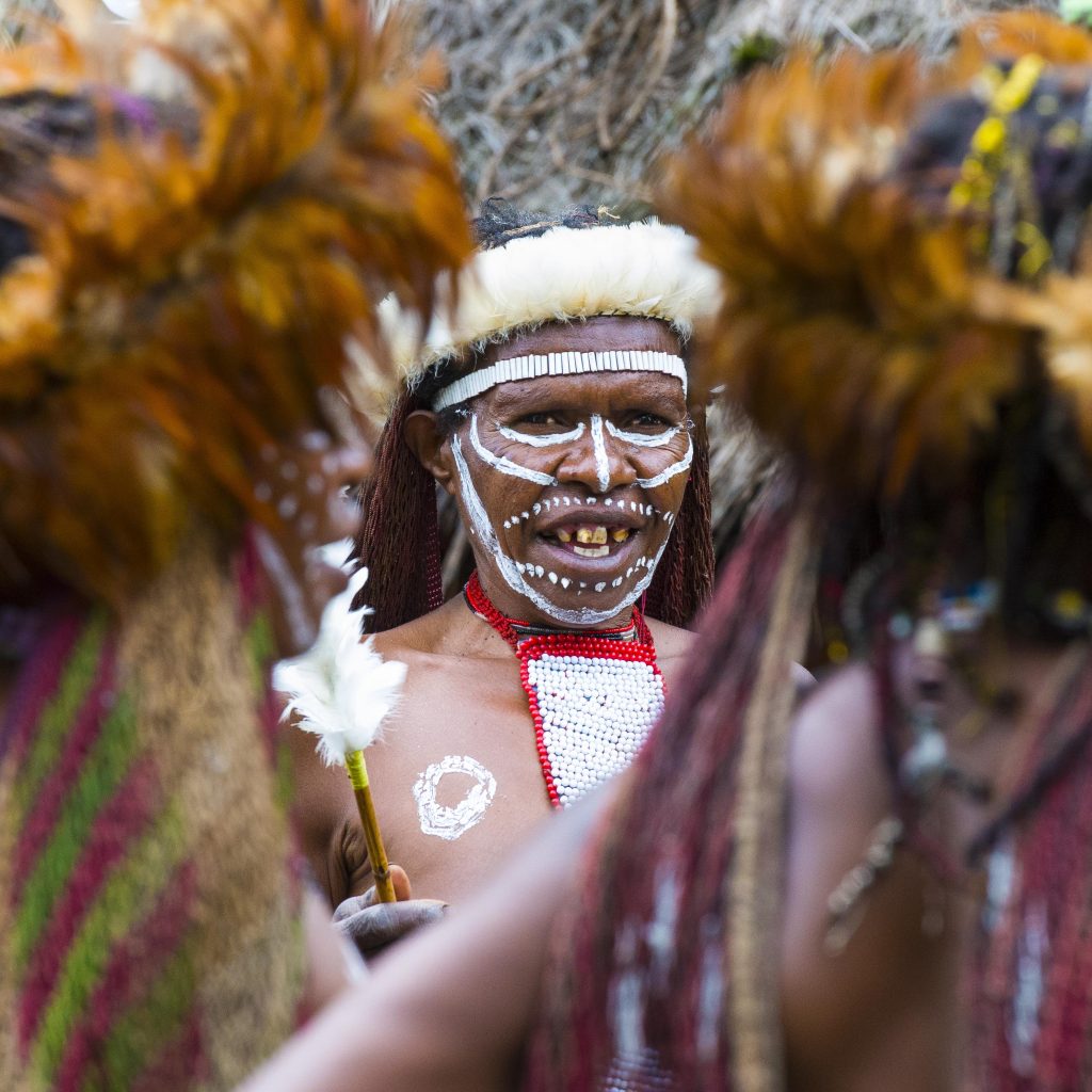 A matriarch from the Dani tribe, dressed in traditional gear, leads a dance in Papua, Indonesia.