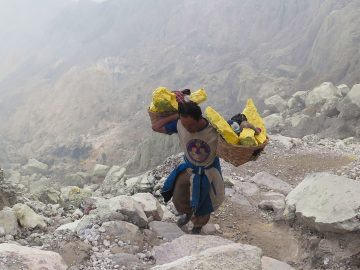 A miner carrying blocks of sulphur climbs from the crater of the Kawah Ijen volcano in Java, Indonesia.