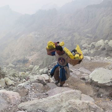 A miner carrying blocks of sulphur climbs from the crater of the Kawah Ijen volcano in Java, Indonesia.