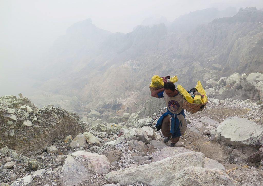 A miner carrying blocks of sulphur climbs from the crater of the Kawah Ijen volcano in Java, Indonesia.