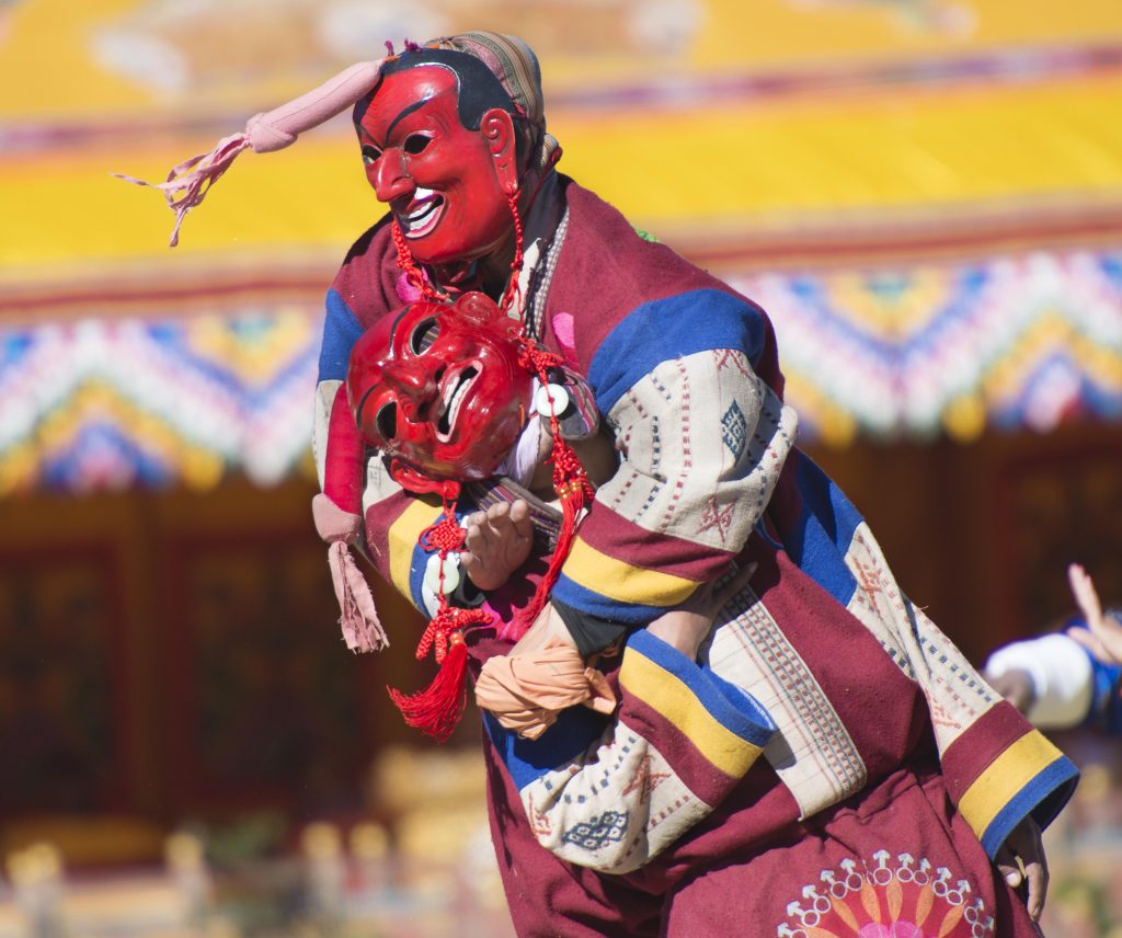 Two clowns or Atsaras wrestle at the Druk Wangyel Tshechu festival near Thimphu, Bhutan.