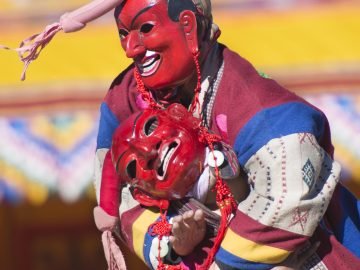 Two clowns or Atsaras wrestle at the Druk Wangyel Tshechu festival near Thimphu, Bhutan.