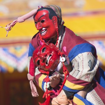 Two clowns or Atsaras wrestle at the Druk Wangyel Tshechu festival near Thimphu, Bhutan.